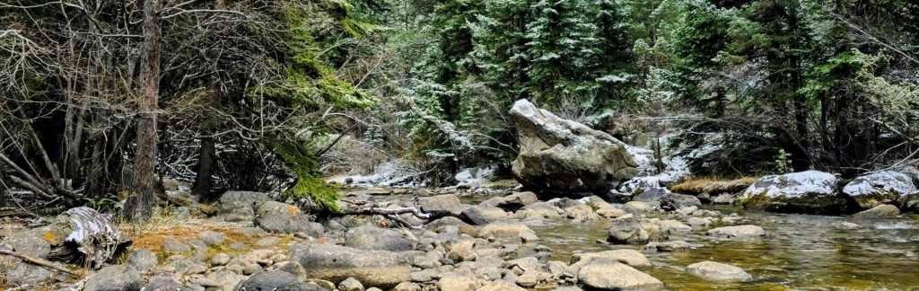 South Boulder Creek on location. A view downstream towards a large boulder pool that might hold large rainbow or brown trout. On a wintery spring day